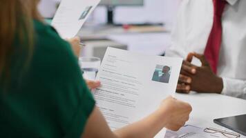 Job candidate hands over his CV to team of HR professionals in order to start interview, focusing on the experience in the resume. Discussing potential career development. Close up. Camera A. photo