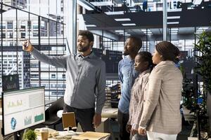 Black corporate employees smiling at photos on smartphone in the office, taking a break from business tasks or operations and enjoying pictures. Friendly happy employees in an enterprise.