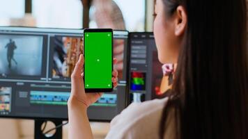 Asian woman working from home as a freelance editor, using isolated mockup display and mixing software. Creative workspace equipped with dual monitors and tech tools. Camera B. photo