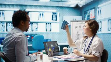 Medical expert discusses test results with a patient in a healthcare setting, utilizing diagnostic tools and computer technology for accurate medical analysis and consultation. Camera B. photo