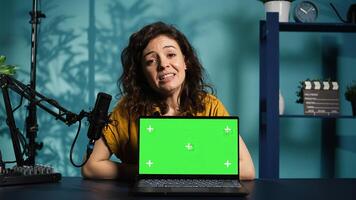 Online show host being sponsored by partnering brand to do isolated screen laptop unboxing content. Tech expert does influencer marketing, doing chroma key notebook product placement, camera B photo