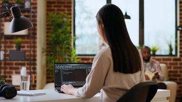 Professional asian software engineer is working remotely typing code on a laptop, using programming language. Woman works on cloud computing, software projects in a digital environment. Camera B. photo