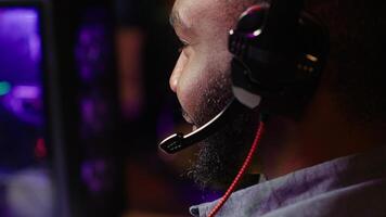Close up of pro streamer streaming videogame on powerful computer during online gaming championship, talking into headset. Gamer taking part in Esport team of gamers, competing in game, camera A photo