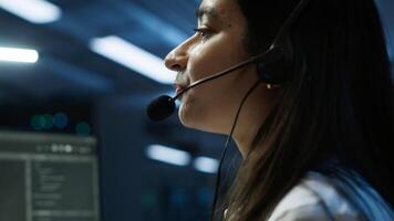 IT expert in data center provides technical support to customers, troubleshooting issues, close up. Server room employee carrying out operational technical interventions requested by clients, camera A photo