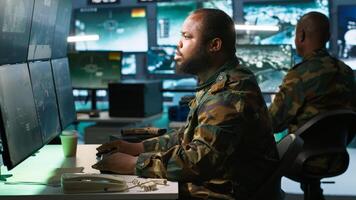 Intelligence corps expert in military HQ base gathering information on enemy troops. Officer arriving at work in base of operations, starting assessment of enemy vulnerabilities, tracking, camera A photo