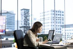 Ambitious woman executive ensuring corporate innovation, exploring new technologies and business models to enhance the company competitive advantage. Evaluating results and analytics. photo