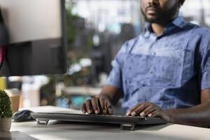 Data scientist typing on keyboard, creating machine learning models that can process and analyze data to improve and automate decision making processes. Close up of man programming in office using PC photo
