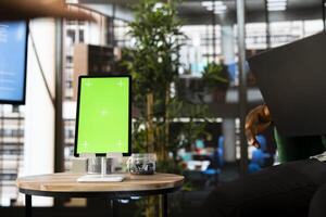 Team of workers in office maintaining relationship with business partners, looking at metrics on green screen tablet. Teamworking colleagues showing shareholders data on mockup device photo
