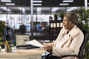Woman holding videoconference meeting with job candidate, asking questions and presenting company background. Human resources employee interviewing for open position during internet videocall photo