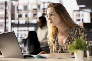 Female CEO engaging in project management using tech tools to set goals and objectives, solve problems and track the performance metrics of the company. Administrative tasks and decisions. photo