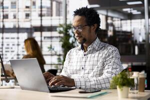 Skilled businessman at his office desk working on report writing, data analysis and deadline management. Male executive looking to expand the enterprise globally, multitasking at job. photo