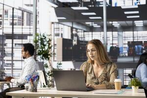 Professional company executive reviews enterprise solutions on her laptop, planning key decisions for growth plan. Entrepreneur focuses on business strategy and financial forecasting. photo
