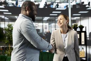 Cheerful managers doing handshake, meeting to implement business strategies to improve operational efficiency and profitability. Happy company directors shaking hand, developing revenue targets photo