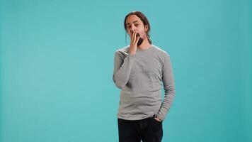 Portrait of bored man lacking enthusiasm to do anything, yawning, wasting time, isolated over studio background. Lazy person living monotonous life, having sleepy dull facial expression, camera A photo
