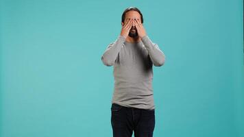 Man covering eyes, ears and mouth, imitating three wise monkeys. Arab person doing dont see, dont hear and dont speak hand gesturing concept, studio background, camera A photo