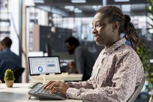 Black business manager engaged in budget analysis and strategy development at workstation, supporting objectives for company growth and employee collaboration. Strategizing business goals. photo