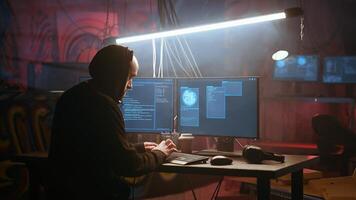 Hacker using high tech computer system to run malicious code in foggy dark basement. Rogue programmer committing illegal activities using PC in neon illuminated criminal hideout, camera A photo