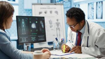General practitioner giving the right diagnosis to woman patient, attending a checkup consultation in medical cabinet. Doctor explaining x ray imaging and scan results, care management. Camera A. photo