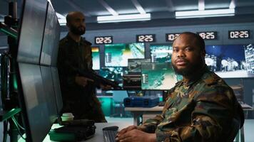 Soldiers working in governmental facility, doing surveillance with digital radar equipment, operating missile systems. Man monitoring army HQ CCTV for any unauthorized activity, camera B photo