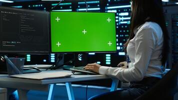 System administrator overseeing data center using green screen computer, ensuring system can handle networking tasks. IT expert in server room tracking network traffic with mockup PC, camera A photo