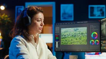producer adds sound effects to film montage, working in studio, close up shot. Videographer using headphones to test and improve audio quality using specialized software, camera A photo
