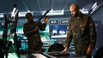 Army soldiers in command center packing weapons able to engage targets at extended range. Military units reloading gun cartridge, preparing for enemy assault mission, camera B photo