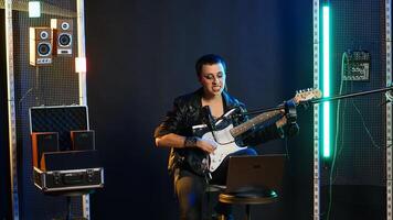 Pleased punk rock artist rehearsing for her live performance, focusing on vocal training and warm up. Edgy iconic woman enjoying singing practice with alternative music. Camera B. photo