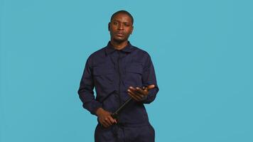 Security guard smacking hand with baton, intimidating suspects. Portrait of bodyguard showing truncheon, threatening to subdue criminals, shaking head, studio background, camera B photo