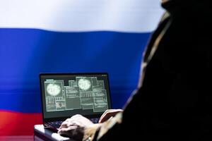 Russian soldier using military tech on laptop to identify threats from enemies. Russia ex KGB FSB personnel using software on notebook device to relay info to war front lines photo