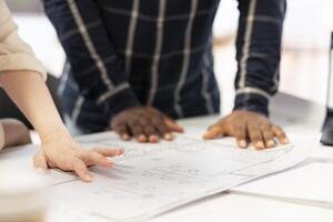 Real estate experts analyzing the layout of the high class office, evaluating important architecture details to potential client. Agents meeting and reviewing property blueprints. Close up. photo