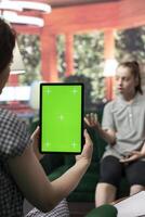 Therapist uses green screen display in a counseling session with an adolescent dealing with low confidence. Psychotherapist supports her in building resilience and self esteem. photo