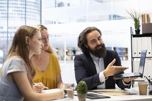 Financial advisor using laptop device to help family build and maintain healthy budget, avoiding overspending. Agent in office using software on notebook to build emergency fund plan for clients photo