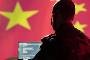 Chinese army telecommunication systems operator using radio and satellite gear, providing combat support. China military dispatcher managing communications networks, looking at laptop screen photo