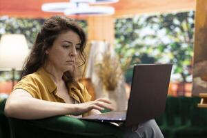 Artist doing research to find contemporary inspiration for a new painting creation, searching for her muse or a rustic model. Woman browsing the internet for creativity and motivation. photo