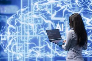 Computer scientist working on laptop, programming artificial intelligence computing simulating human brain. Woman using notebook, developing AI machine learning algorithms photo