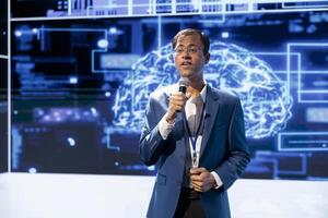 Computer scientist speaking at tech event, explaining impact of artificial intelligence technology. Data analyst presenting risks and threats associated with AI during discussion panel photo