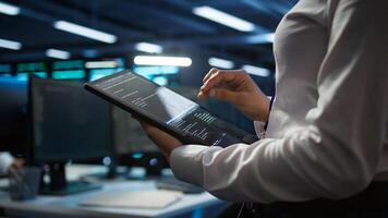 Engineer working in data center used for managing infrastructure rigs energy consumption. Employee using tablet in workplace used for automation and monitoring processes in server farm, camera B photo