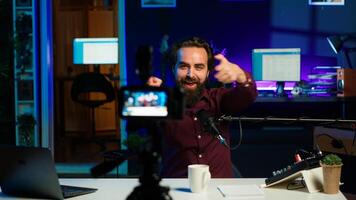Content creator entering home studio, doing cool hand gesturing towards camera during live broadcast on online streaming platforms. Entertainer pointing fingers, captivating audience, camera A photo