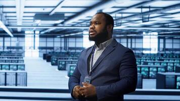 System administrator looking at holograms in data center, monitoring equipment. Employee in server farm interacting with futuristic augmented reality AI visualization, camera A photo