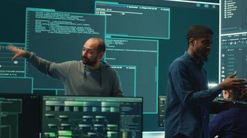 Governmental hackers analyzing cyber threats on big screens, managing important database hacking activity in high tech agency office. Work on cyber defense to protect national security. Camera A. photo