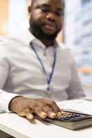 Financial specialist using a calculator to create a projection for retired people income and pension, helping them choose a suitable retirement plan for stability in the future. Close up. photo