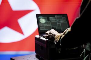 North Korea army operative conducts tactical reconnaissance, utilizing laptop for data analysis and mission planning. Pyongyang regime military agent looks at aerial map on screen, pinpointing targets photo