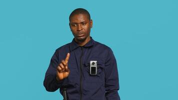 Security guard using cellphone to make call to friends during protection job shift. Portrait of bodyguard in telephone call with mates at work using phone, studio background, camera A photo