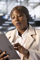Happy CEO in modern startup agency impressed by financial figures on tablet after checking reports. Excited businesswoman working in office, surprised by data metrics on device photo