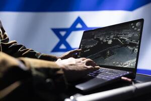 Israel IDF military personnel working on laptop, analyzing aerial reconnaissance data to come up with warfare winning tactics. Close up shot of notebook used to control drones attacking strategic targets photo