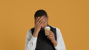 Tired overworked waiter drinking a coffee cup to relax after long shift, working in catering and service oriented environment. Employee feels fatigued and serving caffeine drink. Camera A. photo
