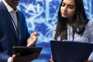 Admins use AI machine learning to extract information from complex data on tablet. Employees in workspace use artificial intelligence technology on device, comparing parameters, close up photo