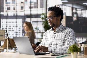Skilled businessman at his office desk working on report writing, data analysis and deadline management. Male executive looking to expand the enterprise globally, multitasking at job. photo