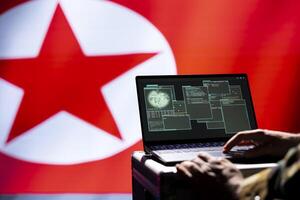 North Korea army soldier using military tech on laptop to identify threats. Close up shot of totalitarian regime agent using notebook to relay info to front lines during korean conflict photo
