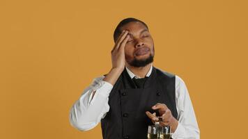 Restaurant employee dealing with a painful headache while he serves clients, carrying a cruet set for excellent customer satisfaction. Unwell waiter in pain with migraine. Camera A. photo